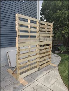 a fence made out of wooden pallets in front of a house