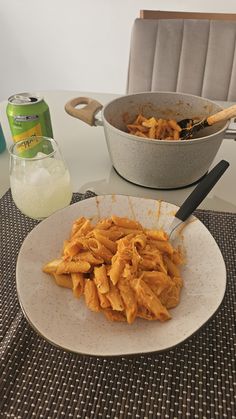 a white plate topped with pasta next to a bowl