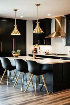 a kitchen with black cabinets and gold accents on the countertop, along with four chairs