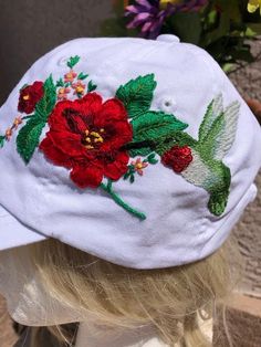 "Hand Embroidered hummingbird base ball hat. A cute mixed-media hummingbird adorns the side of this hat feeding on a bright red flower. The throat sparkles with ruby red sequins. Perfect for hummer the enthusiasts.  100% bio-washed chino twill Unstructured, six-panel, low-profile Pre-curved visor Self-fabric tri-glide buckle closure Size: 6 5/8\" - 7 3/" Embroidered Hummingbird, Felt Cat Toys, Handmade Cat Toys, Sunflower Hat, Sequin Hat, Mom Hats, Floral Hat, Orange Butterfly, Base Ball