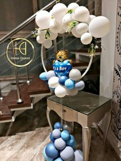 a teddy bear balloon arch with blue and white balloons