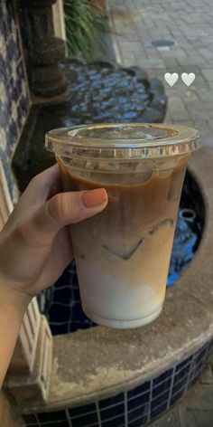 a person holding up a plastic cup with liquid in it