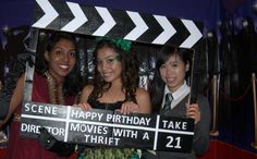 three young women holding up a happy birthday sign for a movie theater themed event with the words scene happy birthday take director's trip