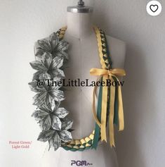 a white mannequin with yellow and green ribbons on it's neck,