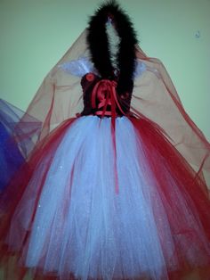 a red, white and blue tutule dress with black fur on the top