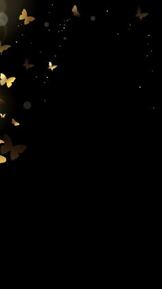 there are many gold butterflies flying in the dark sky with light spots on its wings