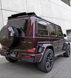 a mercedes g - class is parked in front of a building