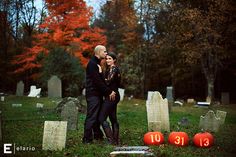 a man and woman standing next to each other in front of tombstones with numbers carved into them