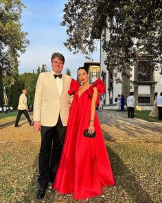 a man and woman in formal wear standing next to each other