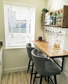 a kitchen table with chairs and a wine glass rack on the wall next to it