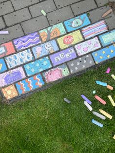 some crayons are laying on the ground in front of a brick wall and sidewalk