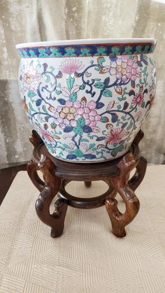 a large bowl sitting on top of a wooden stand