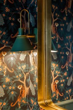 a green lamp is on in front of a wallpapered room with gold trim