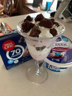 an ice cream sundae with oreo cookies on top and yogurt in the background