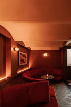 a living room with red couches and round tables