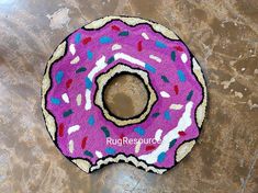 a pink donut rug with sprinkles on it sitting on a table