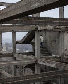 a man walking up some stairs in an abandoned building