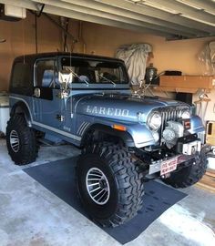 a blue jeep parked in a garage next to another vehicle