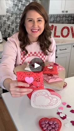 a woman sitting at a table with some heart shaped boxes