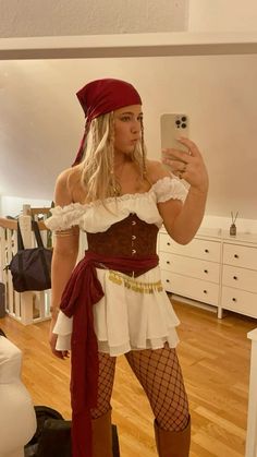 a woman dressed as a pirate taking a selfie