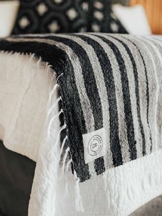 a black and white blanket sitting on top of a bed