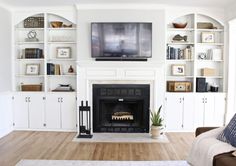 a living room filled with furniture and a flat screen tv mounted on a wall above a fire place