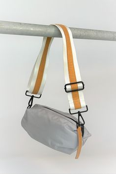 Gray nylon belt bag with white crossbody strap and tan leather detail Fashion Still Life, Sporty Street Style, Lifestyle Accessories, Daily Bag, Straw Bags, Accessories Brand, Orange Bag, Wellness Fitness, Best Bags