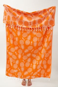 an orange and white towel with pineapples on it, hanging from the side