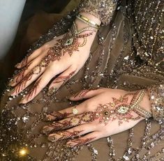 a woman's hands with hennap and jewels on them