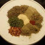 a white plate topped with spices and seasoning on top of a black tablecloth