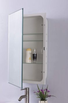 a bathroom sink with a medicine cabinet above it and a vase on the counter next to it