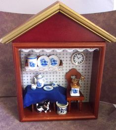 a miniature doll house with blue and white china