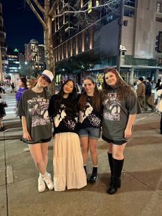 three girls standing next to each other on the sidewalk