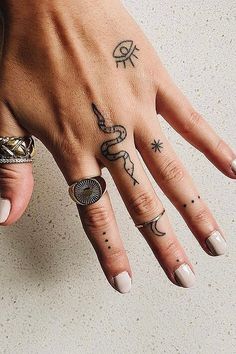 a woman's hand with several tattoos on it