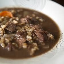 a white bowl filled with beef and rice soup