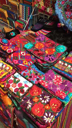 colorful fabrics are on display at an outdoor market