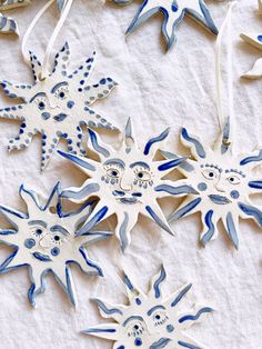 some blue and white ornaments are laying on a tablecloth with other decorations in the shape of snowflakes