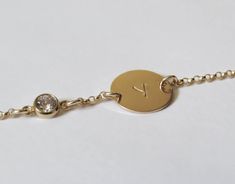 "Simple. Chic. Minimalist™ Super cute initial bracelet for your little daughter. Also a great gift! A brilliant CZ diamond (zirconia) charm and one tiny 14k gold filled tag (11mm), stamped with your choice of comic-font upper-case initial. The 14k gold filled Rollo chain (superb quality) is sparkly and delicate yet very sturdy. All components are 14k gold filled! Bracelet available in the following sizes: 4\"-4.5\" (4\" with half-an-inch of extension chain) 0-1 years old 4.5\"-5\" (4.5\" with ha Personalized Gold Name Bracelet As Bridesmaid Gift, Hypoallergenic Gold Bracelets For Bridesmaids, Gold Hypoallergenic Name Bracelet, Custom Name Gold Bracelet For Bridesmaids, Personalized Gold Charm Bracelet For Bridesmaid Gift, Gold Custom Name Bracelet For Bridesmaids, Gold Name Bracelet For Birthday, Gold Name Bracelet With Birthstone For Birthday, Yellow Gold Bracelets With Birthstone For Personalized Gift