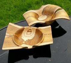 two wooden bowls sitting on top of a black table