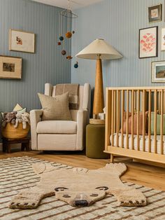 a baby's room is decorated in blue and beige colors with an animal rug on the floor