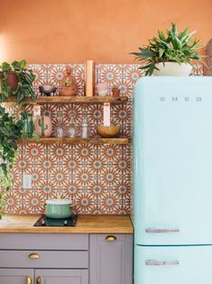 a blue refrigerator freezer sitting inside of a kitchen next to a wooden counter top