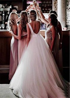 the bride and her bridesmaids are toasting each other in front of the bar