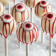 there are many white and red candy lollipops with eyes on them