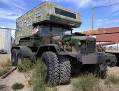 an army truck is parked in the dirt