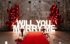 a red carpet is on the floor in front of an archway that says will you marry me?