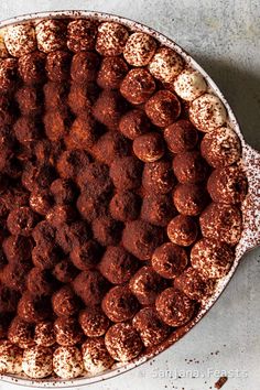 a chocolate cake with powdered sugar on top in a pie pan, ready to be eaten