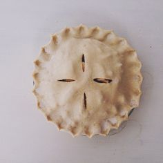 an uncooked pie sitting on top of a white table next to a knife