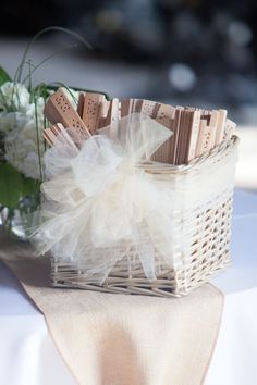 a wicker basket filled with lots of chocolates on top of a white table cloth