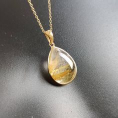 ITEM DESCRIPTION: >>The pendant is made from Solid 14K Yellow Gold. Gemstone used is absolutely natural and ethically sourced. >>Natural Golden Rutile in cabochon cut and pear shape with bezel setting is studded on it with utmost precision. >>This is a minimalist design and is absolutely hassle-free and everyday jewelry. Gem: Golden Rutile Gem size: 12x17 mm Gem weight: 10.36 carats Gold purity: 14K (58.33% approx.) Gold weight: 0.69 grams Gross weight: 2.72 grams The Gold purity is guaranteed a Yellow Gold Teardrop Pendant Jewelry With Large Pendant, 14k Yellow Gold Gemstones For Gift, Yellow Gold Natural Stone Pendant Gemstones, Yellow Gold Pendant Gemstones With Natural Stones, 14k Gold Teardrop Pendant Jewelry With Polished Finish, Anniversary Jewelry With Natural Stones In Teardrop Pendant, Gold Teardrop Gemstones For Formal Occasions, Gold Teardrop Gemstones For Formal Events, Formal Gold Teardrop Gemstones