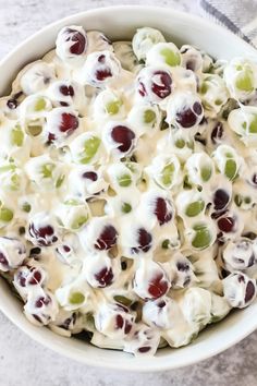 a white bowl filled with grapes and cream